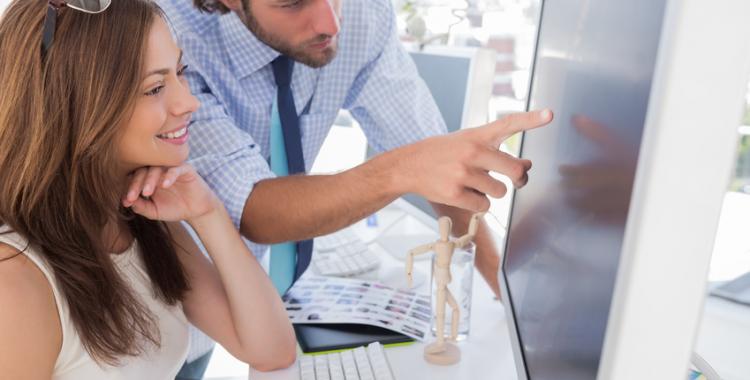 Man pointing something to his partner on screen in creative office